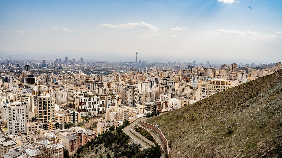 Vue panoramique de la ville de Téhéran avec bâtiments urbains et collines au premier plan.