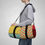 Thumbnail: Person carrying a colorblock duffel bag with polka dots and green stripes