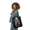 Thumbnail: A woman carrying a Black tote bag featuring an illustrated MS.45 movie poster design with a woman holding a gun.