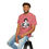 Thumbnail: Man modeling red-pink Ms. Swan MadTV shirt while sitting on stool and smiling.