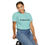 Thumbnail: Woman in mint green Prima Facie T-Shirt, seated and smiling sideways.