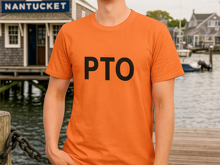 Person standing on a dock in front of a Nantucket building, smiling and wearing an orange T-shirt with the bold black letters "PTO" on it.