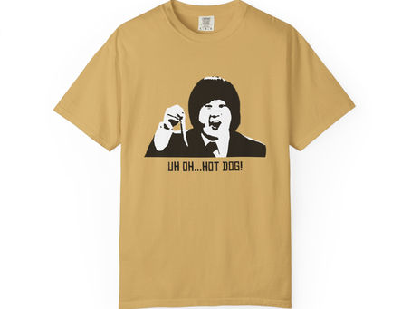 Tan Uh Oh Hot Dog T-shirt folded with Bobby Lee's graphic and quote.
