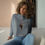 Thumbnail: Woman wearing gray E.T. crop hoodie with curly hair