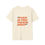 Thumbnail: Flat lay of cream t-shirt with bright orange “F*** Is You Talkin Bout” text design