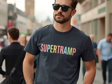 Man wearing a dark gray Supertramp t-shirt with a colorful retro logo, standing confidently on a city street in sunglasses.