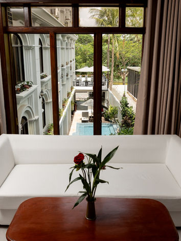 White sofa and wooden table overlooking a hotel courtyard