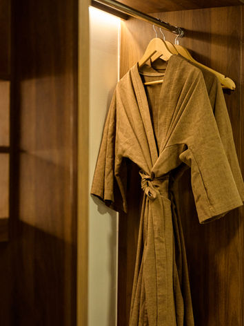 Brown robes hanging in a wooden hotel closet