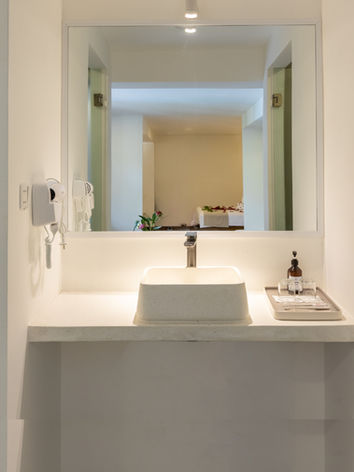 Modern hotel bathroom vanity with white sink and mirror
