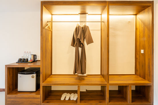 Wooden wardrobe in a room suite with robes and mini-fridge