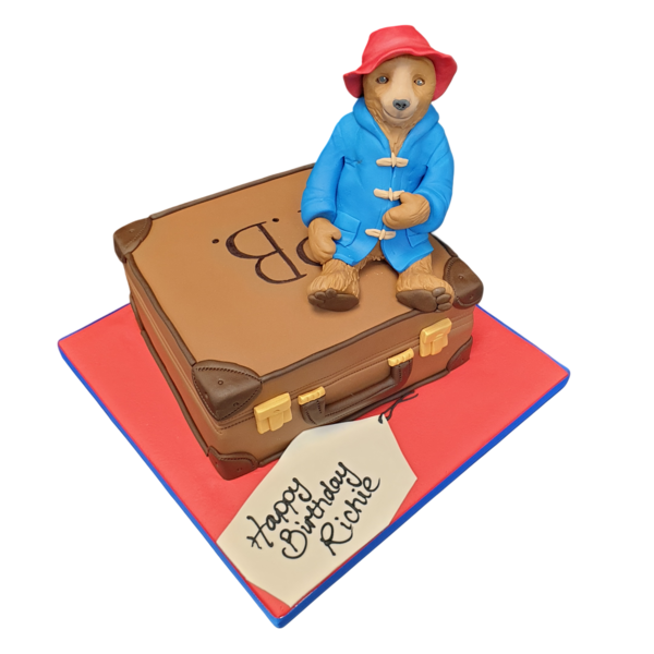A charming Paddington Bear-themed cake, shaped like a suitcase, perfect for fans of the beloved bear. Ideal for themed parties and celebrations.