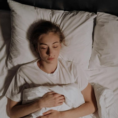 femme allongée dans son lit qui dort mais ne récupère pas - fatigue chronique et système nerveux