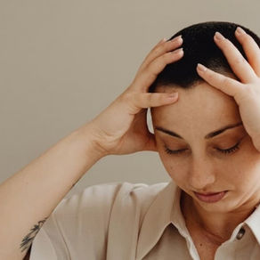 Personne pensive tenant sa tête entre les mains, illustrant la rumination mentale
