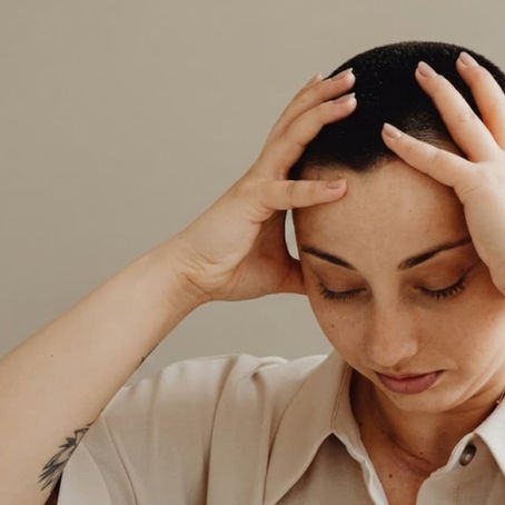 Personne pensive tenant sa tête entre les mains, illustrant la rumination mentale
