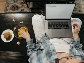 Personne grignotant des chips le soir devant un ordinateur, symbole des envies irrépressibles nocturnes et du craving émotionnel.