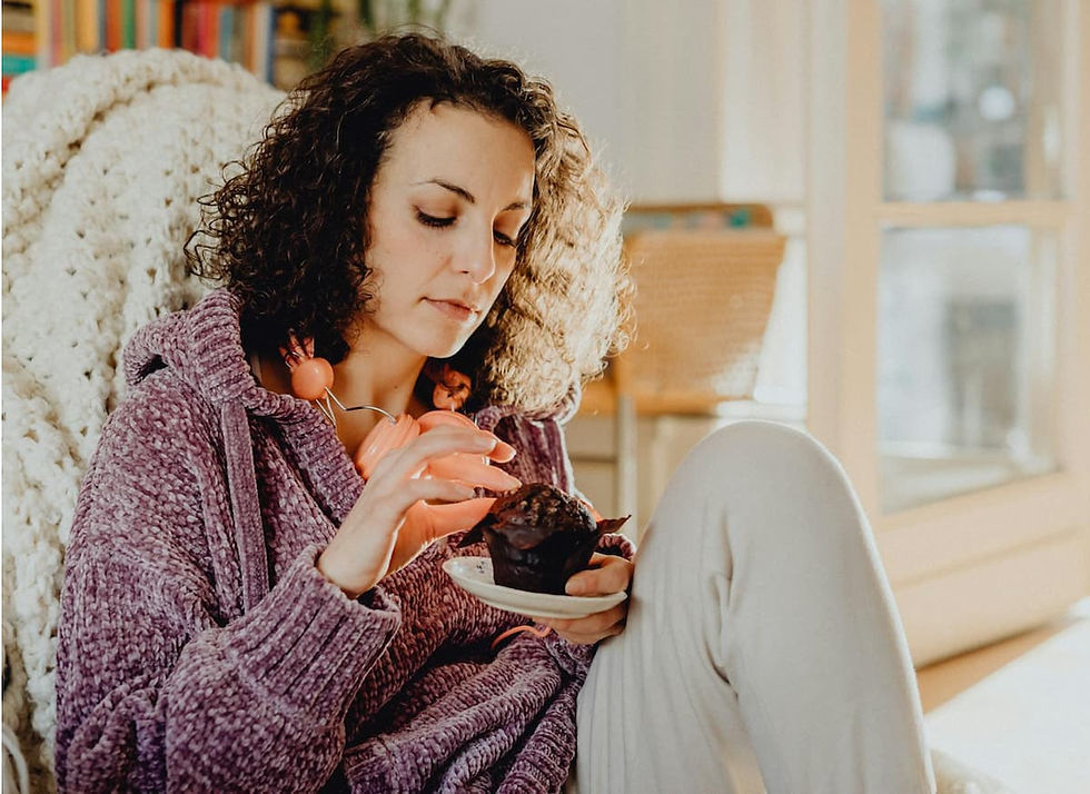 Femme seule chez elle mangeant de façon automatique - compulsions alimentaires émotionnelles