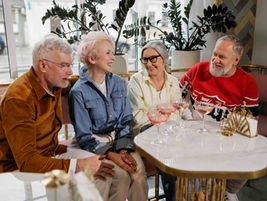 Group of older friends enjoying time together at a café, highlighting the importance of estate planning to protect loved ones and preserve lasting friendships