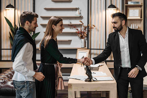 Abogado estrechando la mano de clientes durante una consulta legal