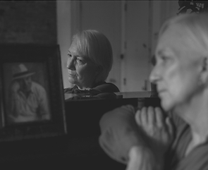 Surviving spouse reflecting beside a framed photo of a loved one, representing grief, loss, and the emotional realities of navigating the Florida probate process.