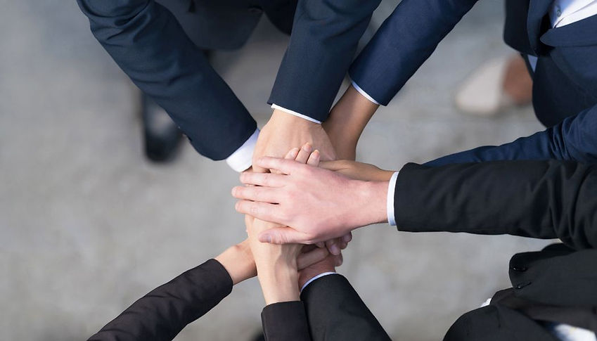 Law firm team members joining hands together in a show of unity and collaboration