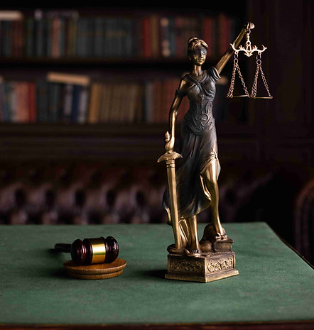 Lady Justice statue holding scales beside a judge's gavel in a law library, representing probate law and estate administration in Florida