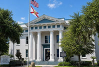 The historic Brevard County Courthouse in Titusville, Florida, where probate and guardianship matters are handled, showing its classic columned entrance and surrounding oak trees with Spanish moss