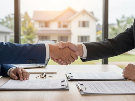 Two people shake hands over real estate documents and house keys, with a home in the background — settling an Oregon partition dispute without a lawsuit.