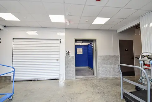 Elevator lobby at University Self Storage with blue padded freight elevator and nearby climate-controlled storage units