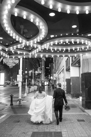 Bride and groom walking under lights in Playhouse Square