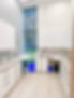 Espace de laboratoire moderne avec armoires blanches, tiroirs et grande fenêtre.