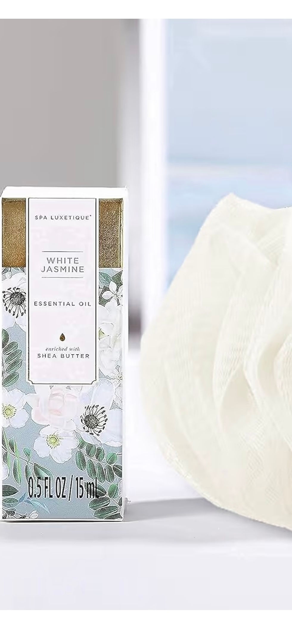 Miniature : A product package with daisy illustrations and a white bath sponge beside it.