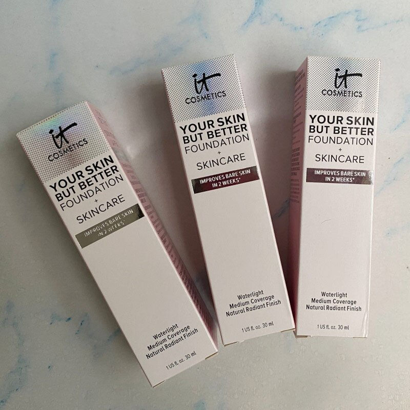 Miniaturbild: Three IT Cosmetics foundation boxes, Your Skin But Better, skincare, on marble surface.