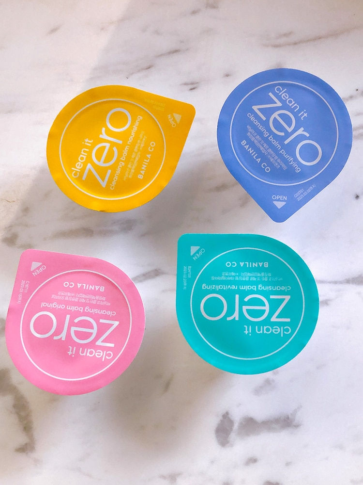 Thumbnail: Four colorful Clean It Zero makeup removal balm pods on white marble