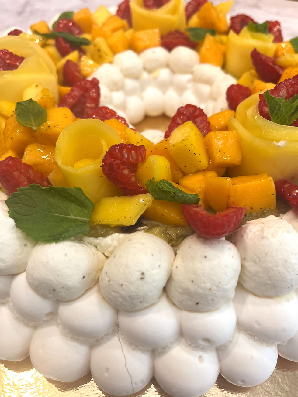 Détail pavlova garni de mangue fraîche, framboises et feuilles de menthe