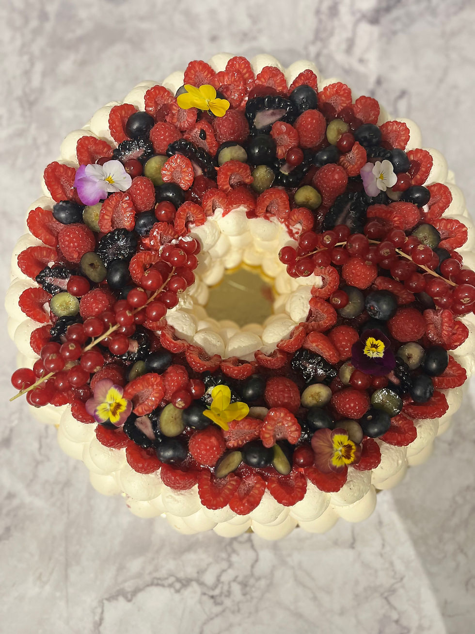 Pavlova de fête garnie de fruits rouges frais sur meringue craquante