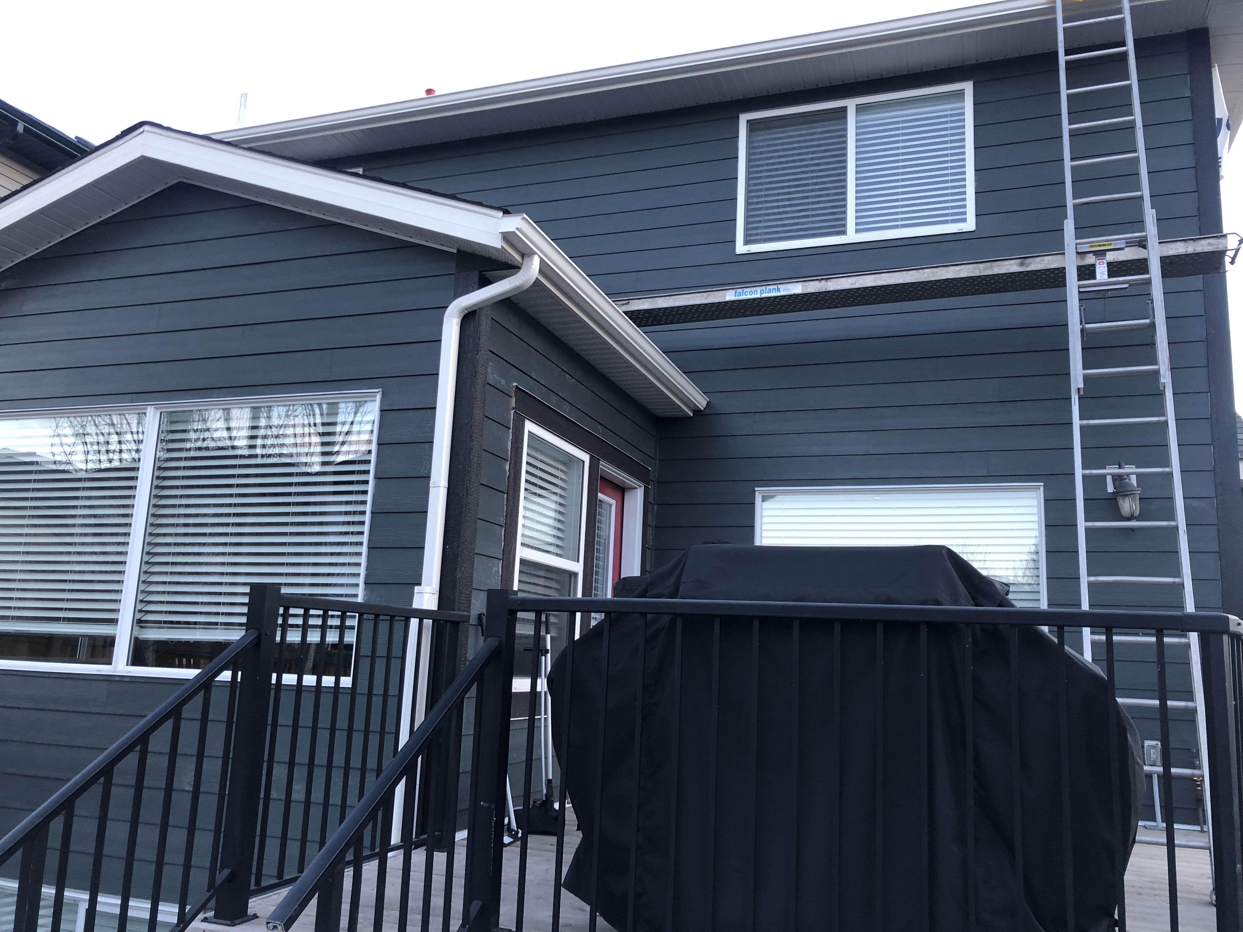 Blue exterior siding with white window and door trim