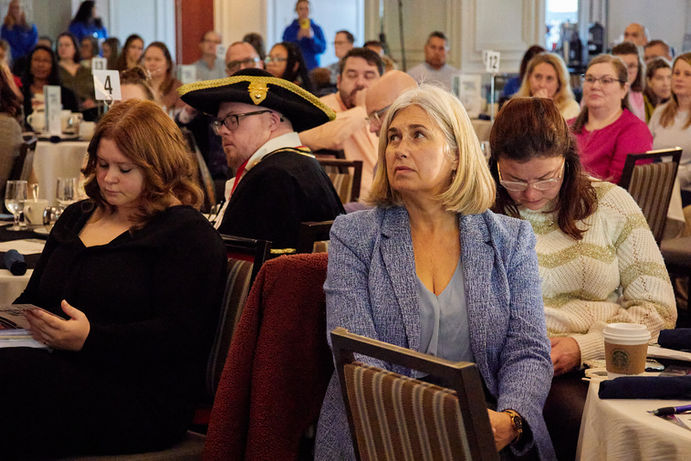 Attendees sitting at table listening