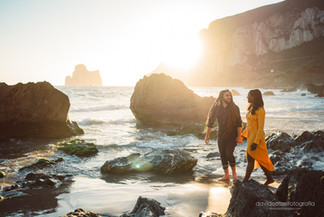 Coppia che si guarda in  spiaggia a masua al tramonto con il pan di zucchero nello sfondo