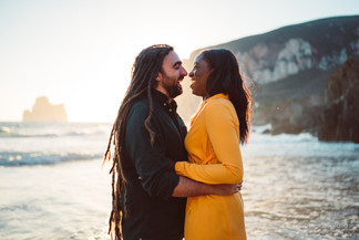 Coppia che si guarda in  spiaggia a masua al tramonto con il pan di zucchero nello sfondo