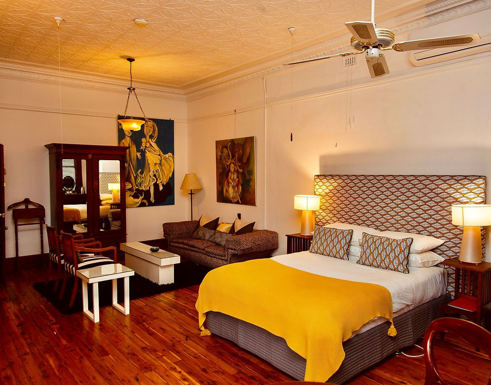 Spacious boutique accommodation. Bedroom with artistic vibes and cozy seating area. "Elephant at the Table"