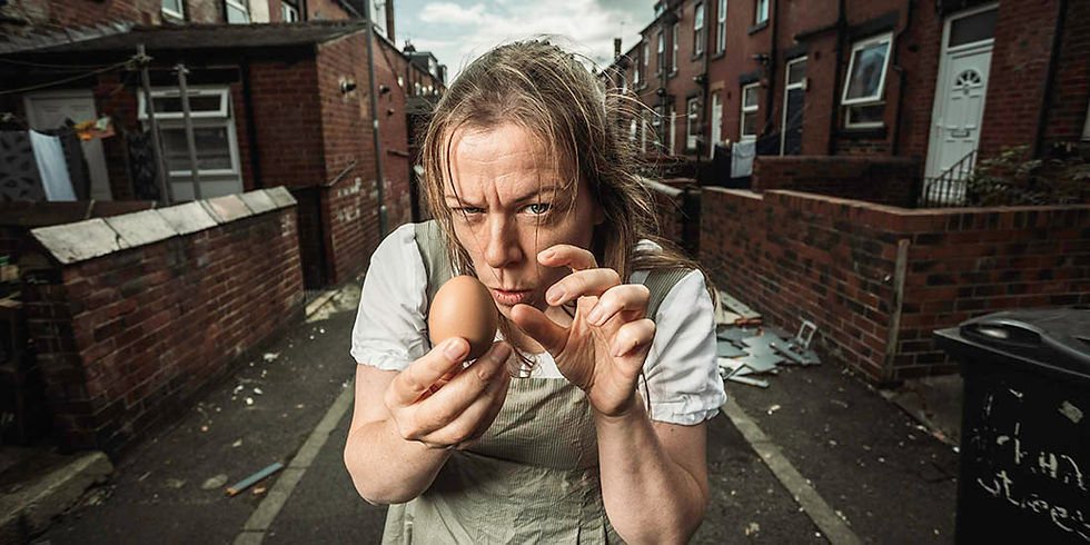 A woman with an egg in an alleyway between rows of houses, northern UK. Illustrattive imafe for new play Mutton, by Chris Singleton