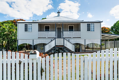 A white house infront of a picket fence