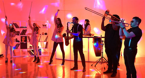 Live wedding band performing with singers and horn section on stage.