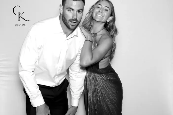 Man in white shirt and woman in shimmering dress pose playfully against a plain backdrop. Text reads "CK 07.21.24." Smiling and joyful mood.