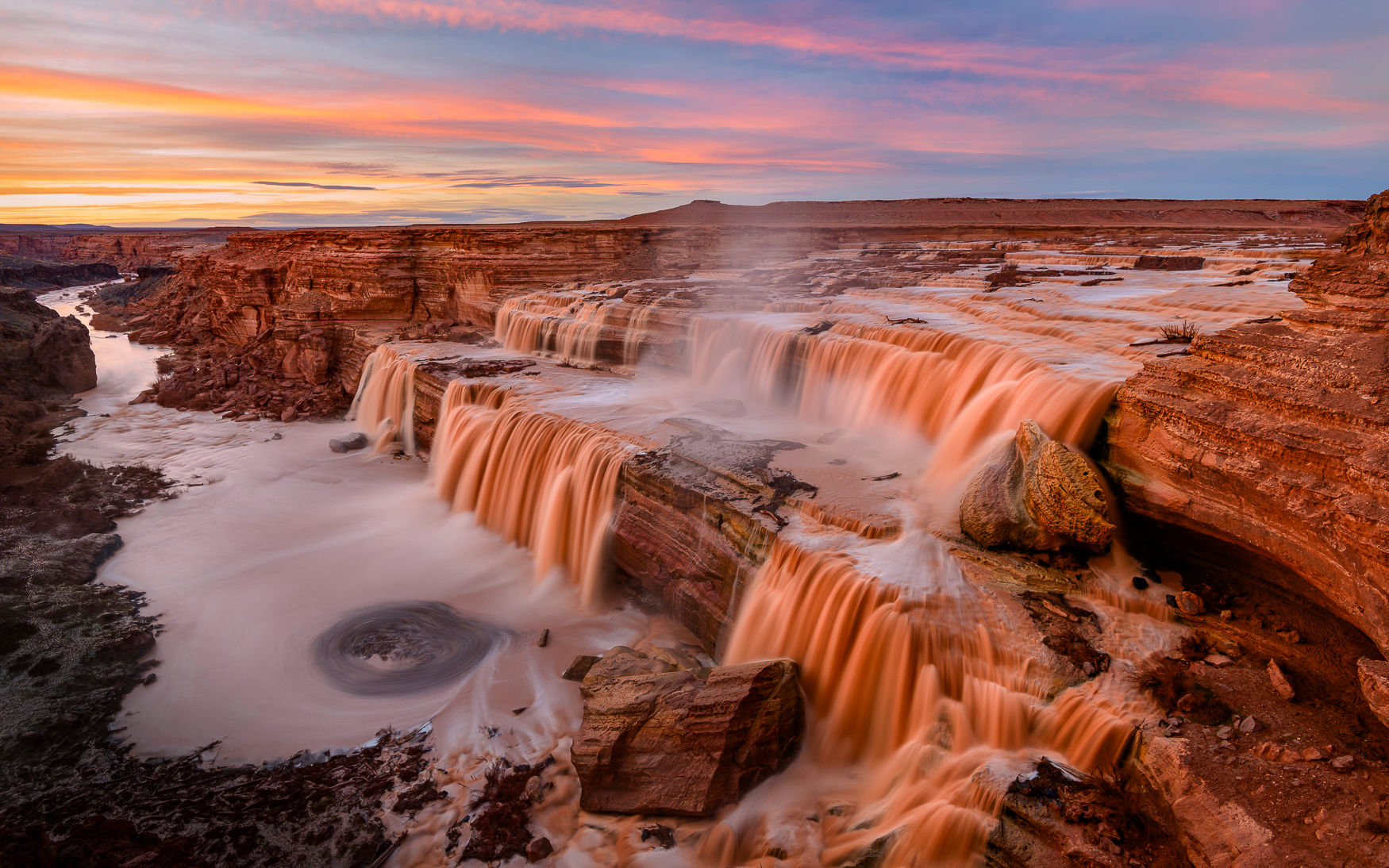 Grand Falls cascading down layered rock formations into a swirling pool.