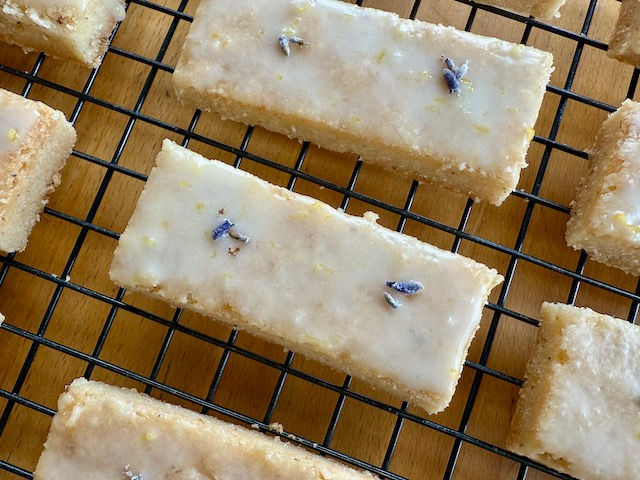 Thumbnail: Lavender Lemon Shortbread cookies on a white plate cooling rack.