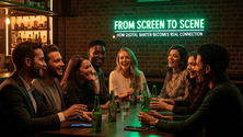 A group of friends laughing and chatting in a modern bar with Heineken bottles on the table, phones turned face-down, and a neon sign reading “From Screen to Scene.” The image symbolizes digital conversations turning into real-life connection.