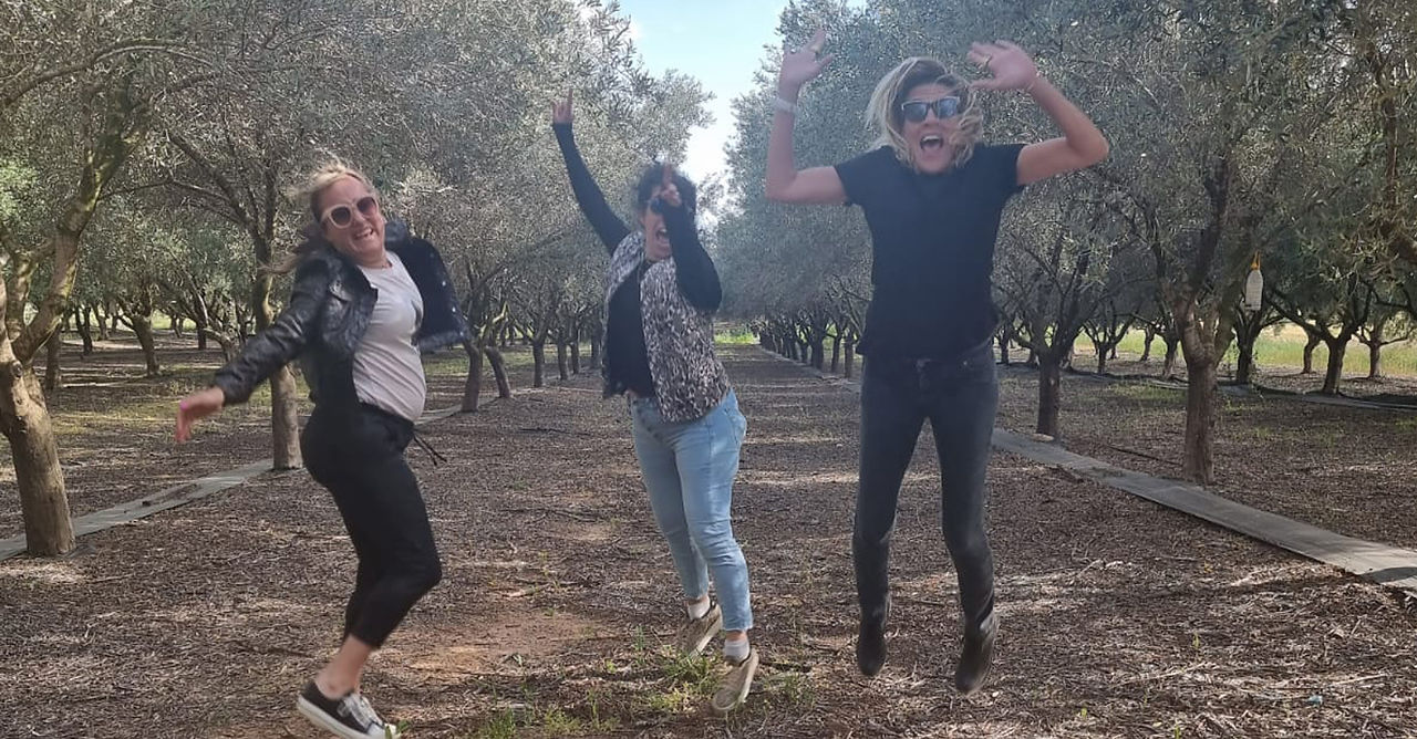 שלוש נשים קופצות באוויר בשמחה בטבע, ערב נשים עצמאיות בשרון, צילום בחוץ