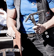 Dachdecker mit Zimmererhammer in der Hand