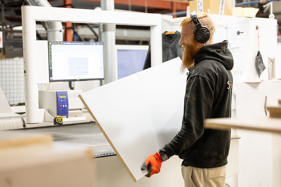 A skilled factory working building bespoke kitchen cabinets.